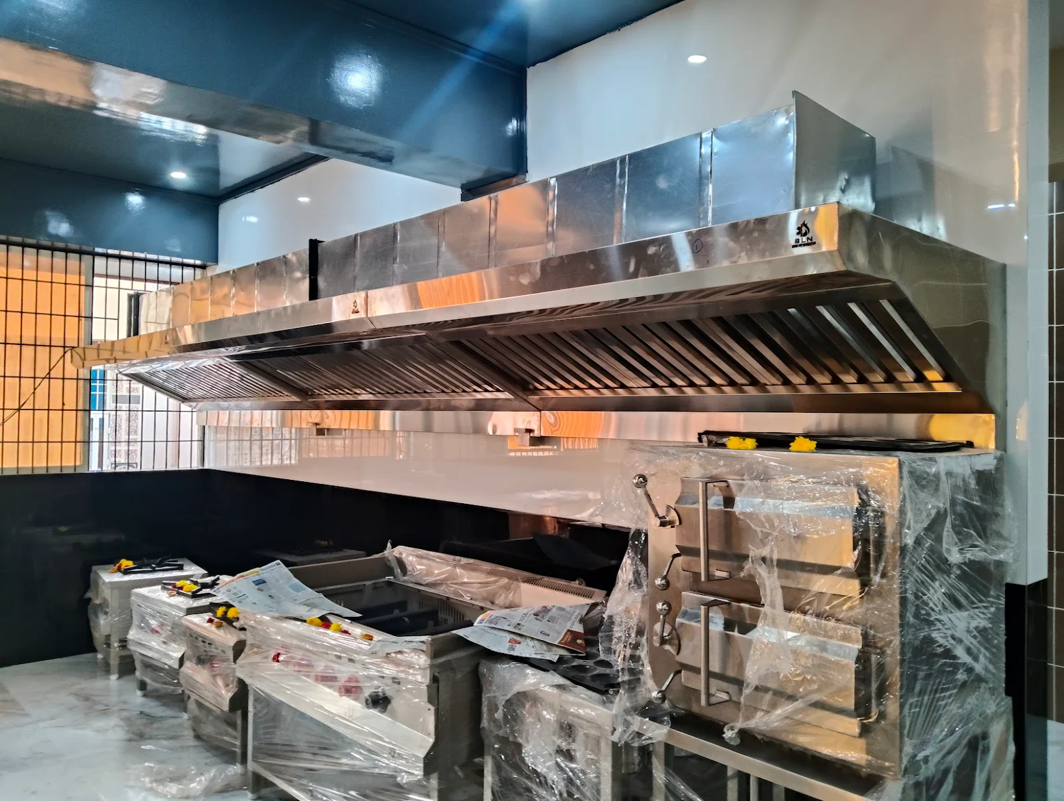 Commercial kitchen exhaust hood above cooking equipment during installation