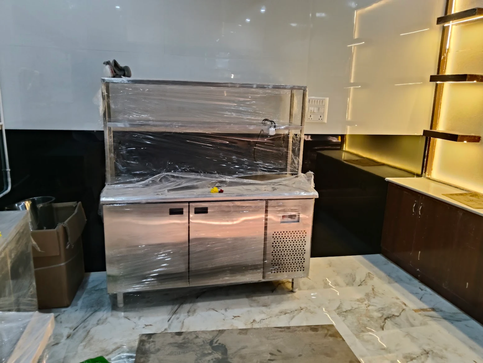 Stainless steel refrigerated counter with upper preparation storage during installation